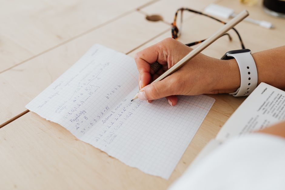 Öğrencinin matematik ders notları tutarken problem çözdüğü yakın plan görüntü